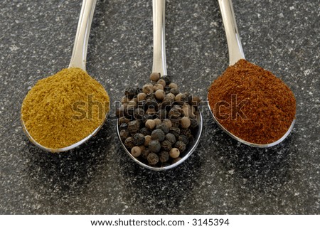Three Spices, Curry, Peppercorns And Chili Powder, Measured Out On Teaspoons