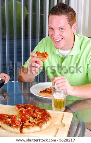 Young Handsome Man Wearing A Green Golf Shirt, Eating Pizza