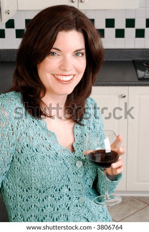 Attractive Young Woman Relaxing And Enjoying A Glass Of Red Wine At Home