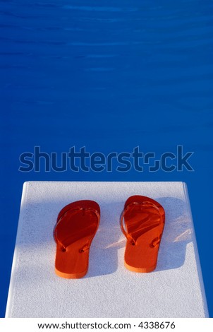 Pair Of Flip Flop Thongs On A Diving Board At A Swimming Pool