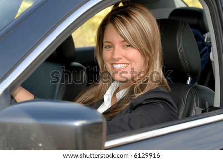 Attractive Smiling Blond Businesswoman Driving Her Car