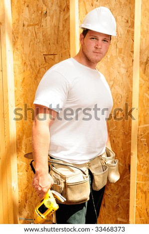 Home Builder Wearing A Hard Hat And Holding A Power Drill