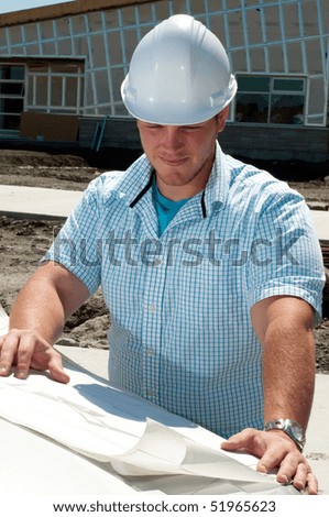 Young Building Contractor Checking The Plans To A New Commercial Building