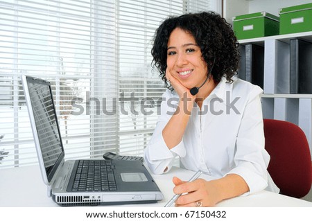 Call Center Woman Wearing A Telephone Headset At Her Desk In The Office
