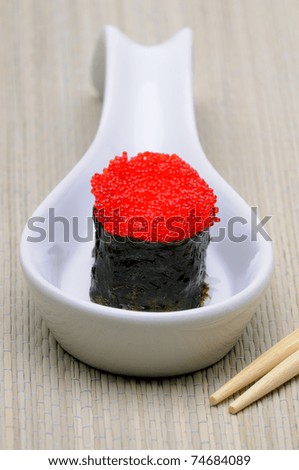Brightly Colored Red Tobiko Flying Fish Roe  (Eggs) On A Sushi Roll
