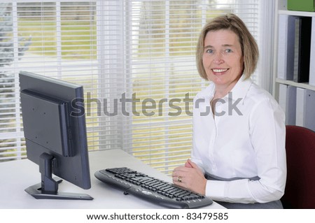 A Middle Age Woman Working With A Computer In Her Office