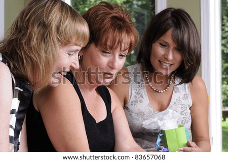 Three Woman Giving A Surprise Gift To Their Friend