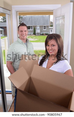 Young Couple Moving Into A New Home, Unpacking Cardboard Boxes