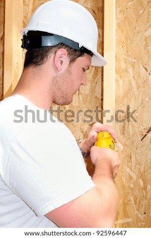 General Contractor Builder Using A Power Screw Driver While Building A New Home
