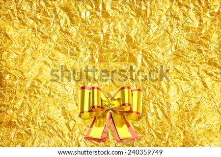 Shiny yellow leaf gold and  ribbon on Shiny foil texture background