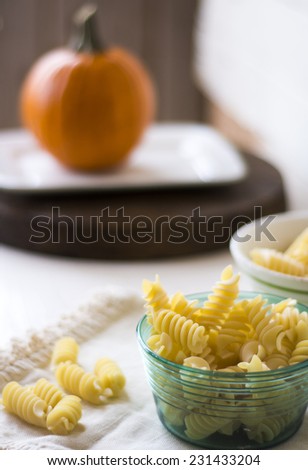 Pasta In Teal Glass Bowl With Pumpkin In Background