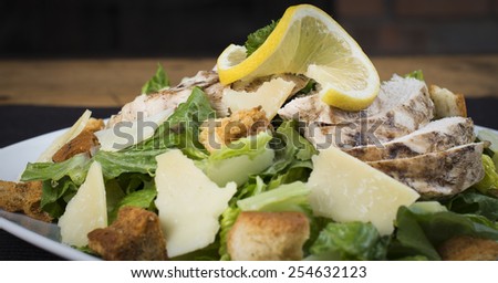 A closeup of a gluten free chicken Caesar salad.  The view is from the side.