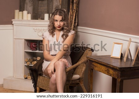 beautiful girl sitting in a chair by the fireplace