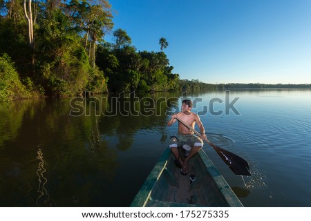 Puerto Maldonado, Madre De Dios - Peru, Circa 2013: Instant Of A Unidentified Man Paddling His Boat In The River, Circa 2013 In Puerto Maldonado. The Rivers Are The Main Roads In The Amazon Jungle.