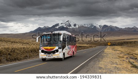ANCHASH - PERU, CIRCA 2013: Instant of a passenger bus traveling the road with a snowy mountain in the background circa 2013 in Ancash. The roads in Ancash cross very beautiful landscapes for tourism.