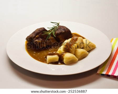 Roasted wild game in ginger bread sauce with potato dumplings