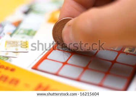 a human hand is scratching a lottery ticket