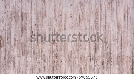 Wooden garage wall with flaked paint and rusty nails