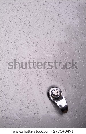 Water droplets on metallic gray trunk lid