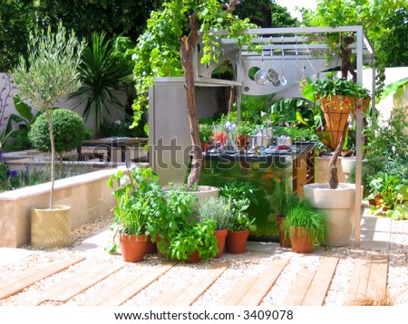 Modern kitchen in the garden with fresh green plants