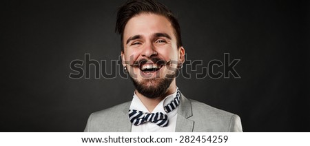 Smiling hipster in suit on dark story background