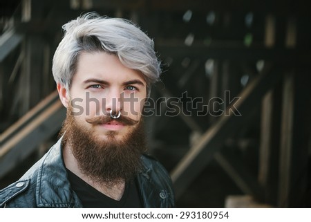 Bearded hipster with nose ring in leather jacket outdoor