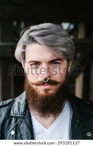Bearded hipster with nose ring in leather jacket outdoor