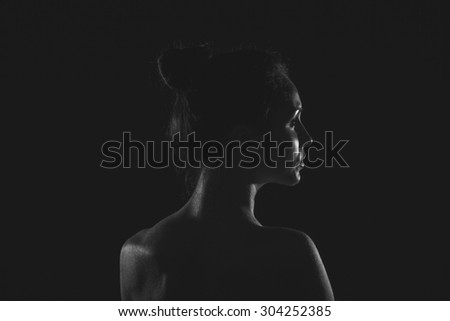 beautiful young woman in dark studio closeup black and white