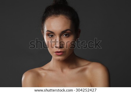 beautiful young woman with healthy face and clean skin on black background