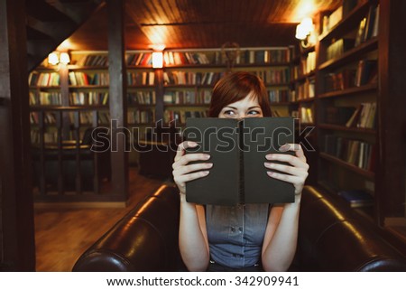 Beautiful female student in a university library reading book