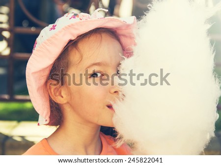 Cute girl with white cotton candy. Toned