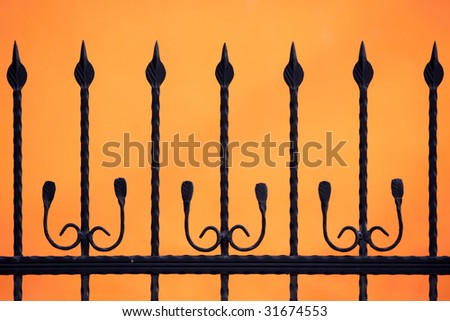 black fence silhouette on orange background