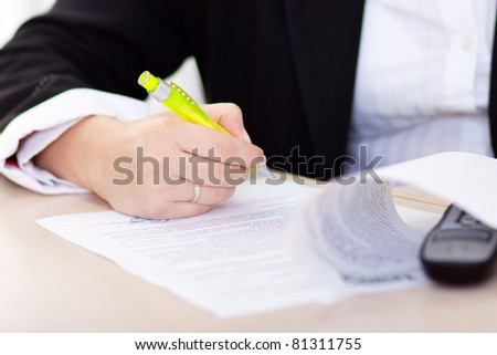 hand of the businesswoman writing note (hand with pen in focus)