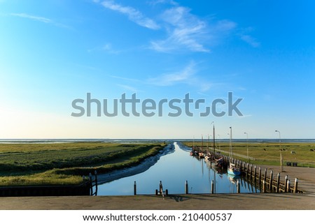 A very small sea harbor at the Wadden Sea. At the moment of this photo it\'s, due to low tide, not possible to leave the harbor.