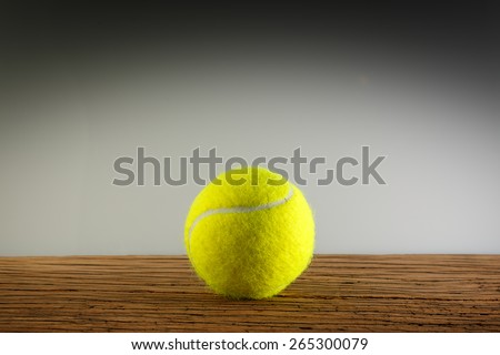 New yellow tennis balls on a wooden table. In light and shadow. Copy space room text.