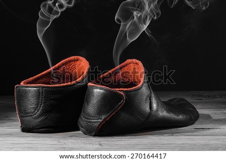 Empty slipper shoe design with smoke rise. Concept speed, smell, empty, leave. On black background with creative light.