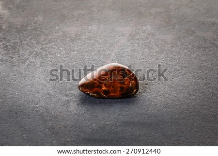 Piece of pietersite originating from Namibia Africa on stone surface. Metamorphic gem stone type of tiger eye.
