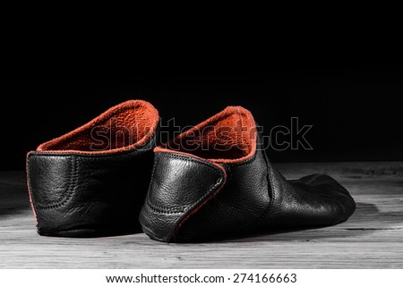Empty slipper shoe design at home in creative light. Concept relax, weekend, rest. On black background.