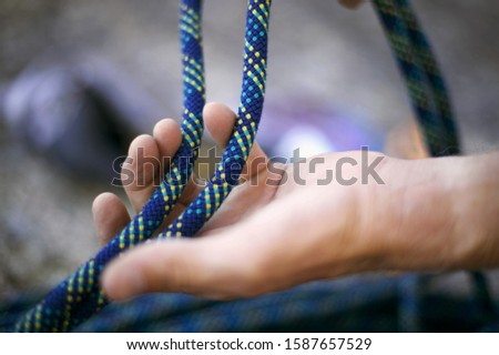 Detail view of hand holding rock climbing rope