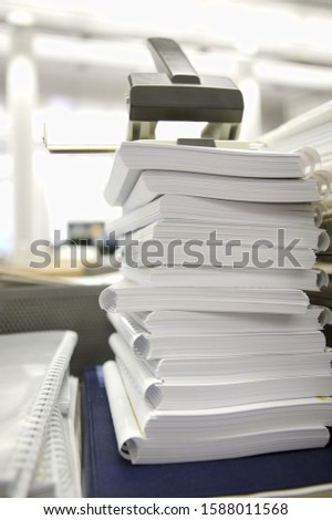 Hole puncher on top of stack of paperwork