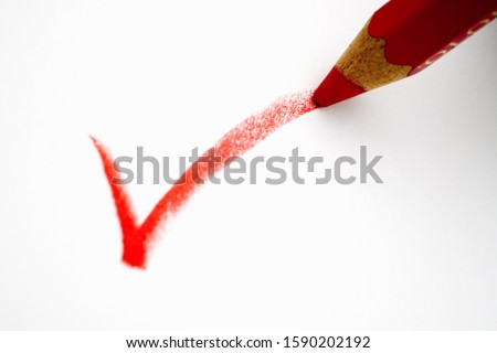 Red pencil writing a check mark