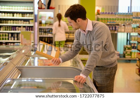 Man shopping in freezer section of organic grocery store