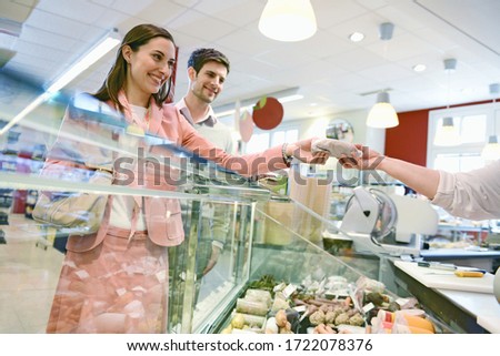 Customers shopping at the deli counter in organic grocery store