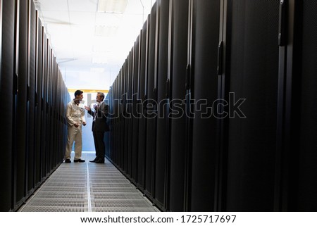 Computer technician and businessman talking in server room in Cape Town, South Africa