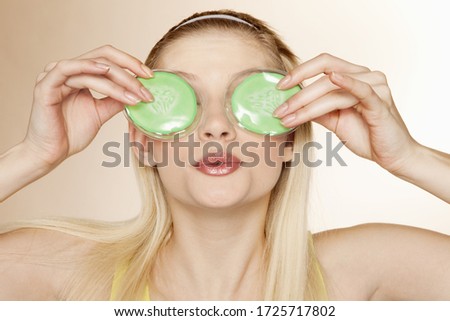 Young holding eye packs, studio shot