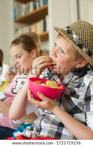 Young boy with friends eating potato chips