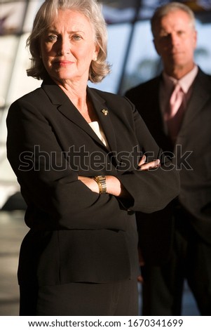 Portrait of senior businessman and businesswoman in airport building