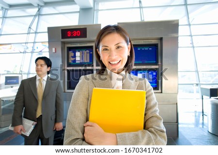 Portrait of businesswoman in airport by flight information screen