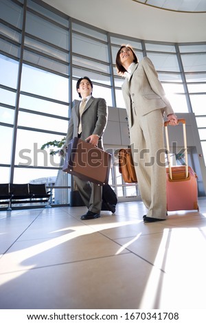 Business colleagues on trip in airport building with luggage