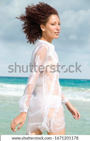 Young woman walking in ocean, side view, Havana, Cuba